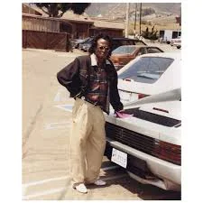 Miles Davis wearing Chino Pants with his ferrari
